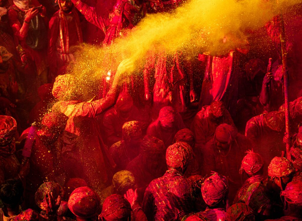 Colorful Holi celebration with people enjoying vibrant powder in Vrindavan, India.