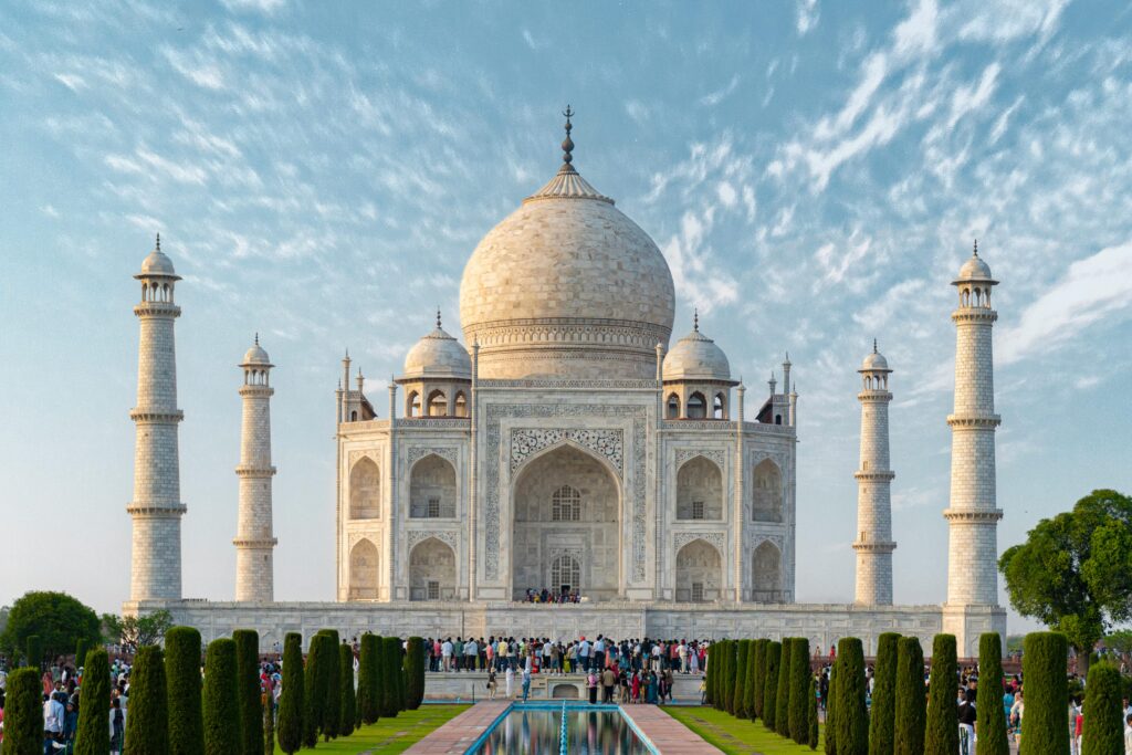 Explore the iconic Taj Mahal, a UNESCO World Heritage Site in Agra, India, captured under a bright blue sky.